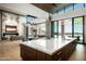 Open kitchen with breakfast bar, marble countertops, wood cabinets, and view to the living room at 9643 E Cintarosa Pass, Scottsdale, AZ 85262