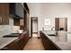 Modern kitchen with marble countertops, stainless steel appliances, and dark wood cabinetry at 9643 E Cintarosa Pass, Scottsdale, AZ 85262