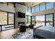 Bright main bedroom with stone fireplace, a private deck, and hardwood floors at 9643 E Cintarosa Pass, Scottsdale, AZ 85262