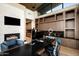 Modern office with a cozy fireplace and stylish built-in cabinets at 9643 E Cintarosa Pass, Scottsdale, AZ 85262