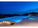 Stunning infinity pool at twilight with fire feature and city views at 9643 E Cintarosa Pass, Scottsdale, AZ 85262