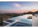 Modern infinity pool offering scenic mountain and desert views at sunset at 9643 E Cintarosa Pass, Scottsdale, AZ 85262
