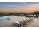 Luxury poolside lounge area with sunset view over desert mountains at 9643 E Cintarosa Pass, Scottsdale, AZ 85262