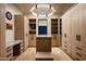 Spacious walk-in closet with custom cabinets, marble island, and elegant lighting at 9643 E Cintarosa Pass, Scottsdale, AZ 85262