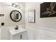 Stylish powder room with a round mirror, modern vanity, and decorative wall art creates an inviting space at 10220 E Isleta Ave, Mesa, AZ 85209