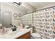 Bright bathroom featuring a large mirror, stylish vanity, and a shower with colorful bird-themed curtain at 10220 E Isleta Ave, Mesa, AZ 85209