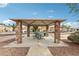 Covered picnic area with stone supports, offering a gathering space in the community park at 10220 E Isleta Ave, Mesa, AZ 85209