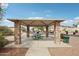 Community park shelter with stone pillars and a metal roof providing a shaded picnic area at 10220 E Isleta Ave, Mesa, AZ 85209