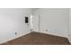 A bedroom with neutral carpeting and a door leading to another room at 11856 W Grant St, Avondale, AZ 85323