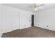 A bedroom with neutral carpeting, a ceiling fan, and two doors at 11856 W Grant St, Avondale, AZ 85323