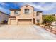 Two-story home featuring a three-car garage and desert landscaping at 11856 W Grant St, Avondale, AZ 85323