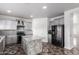 Kitchen with gray cabinets, granite island, black appliances, and subway tile backsplash at 11856 W Grant St, Avondale, AZ 85323