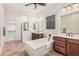 Luxurious bathroom with a soaking tub, dark wood cabinets, and modern fixtures, offering a spa-like experience at 13641 W Jesse Red Dr, Peoria, AZ 85383