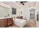 Bathroom with a soaking tub, wooden vanities, tile flooring, and a spacious layout for relaxation at 13641 W Jesse Red Dr, Peoria, AZ 85383