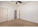 Inviting bedroom with soft carpeting, closet, ceiling fan, and convenient access to the en-suite bathroom at 13641 W Jesse Red Dr, Peoria, AZ 85383