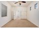 Sunlit bedroom showcasing a ceiling fan, three windows, neutral carpeting, and a closet with sliding doors at 13641 W Jesse Red Dr, Peoria, AZ 85383