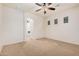Spacious bedroom with carpet flooring, a ceiling fan, and natural light, showcasing an archway at 13641 W Jesse Red Dr, Peoria, AZ 85383