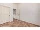 Bedroom with tiled floor, double closet doors and a doorway leading to another room at 13641 W Jesse Red Dr, Peoria, AZ 85383
