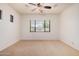 Bedroom featuring carpet floors, a ceiling fan, and a large window, perfect for relaxation at 13641 W Jesse Red Dr, Peoria, AZ 85383