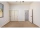 Light-filled bedroom featuring sliding closet doors, a window with blinds, and neutral carpeting at 13641 W Jesse Red Dr, Peoria, AZ 85383