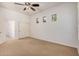 Bright bedroom featuring a ceiling fan, three windows, neutral carpeting, and a closet with sliding doors at 13641 W Jesse Red Dr, Peoria, AZ 85383
