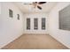 Bright bedroom featuring carpet, a ceiling fan, and multiple windows with views at 13641 W Jesse Red Dr, Peoria, AZ 85383