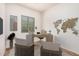Virtually staged home office with decor including a wooden desk, two chairs, and a world map at 13641 W Jesse Red Dr, Peoria, AZ 85383