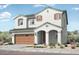 Charming two-story home featuring a welcoming front porch, a two-car garage, and desert landscaping at 14467 W Sand Hills Rd, Surprise, AZ 85387