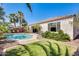 Beautiful backyard oasis with a sparkling pool, lush landscaping, and outdoor seating area at 15613 W Minnezona Ave, Goodyear, AZ 85395
