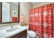 Well-lit bathroom with a vanity, a large mirror, and a shower with a decorative shower curtain at 15613 W Minnezona Ave, Goodyear, AZ 85395