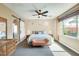 Spacious bedroom featuring a ceiling fan, barn door and large window offering an abundance of natural light at 15613 W Minnezona Ave, Goodyear, AZ 85395