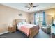 Comfortable bedroom with ample natural light, ceiling fan, warm accent wall, and cozy seating area at 15613 W Minnezona Ave, Goodyear, AZ 85395