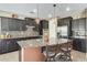Well-equipped kitchen featuring dark cabinetry, granite counters, and a spacious center island at 15613 W Minnezona Ave, Goodyear, AZ 85395