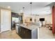Open kitchen featuring granite counters, stainless appliances, and seamless flow into the living area at 15613 W Minnezona Ave, Goodyear, AZ 85395