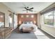 Cozy main bedroom with ceiling fan, sliding barn door, and three vertical windows at 15613 W Minnezona Ave, Goodyear, AZ 85395