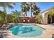 Tranquil pool area with waterfall feature, lounge chairs, and mature palm trees for a resort-like feel at 15613 W Minnezona Ave, Goodyear, AZ 85395