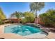 Sparkling pool features a waterfall and is surrounded by lush landscaping and mature palm trees at 15613 W Minnezona Ave, Goodyear, AZ 85395