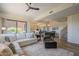 Bright, open-concept living room featuring a comfortable sofa, modern ceiling fan and seamlessly connects to the dining area at 16248 E Ridgeline Dr, Fountain Hills, AZ 85268