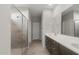 Bright main bathroom with double vanity, walk-in shower, and grey tile flooring at 17794 W Getty Dr, Goodyear, AZ 85338