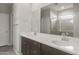 Bathroom featuring double vanity with solid surface countertops and walk-in shower at 17794 W Getty Dr, Goodyear, AZ 85338