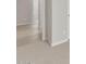 Bright hallway with neutral color scheme featuring light gray walls and neutral-toned tile and carpet at 17794 W Getty Dr, Goodyear, AZ 85338