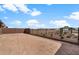Wide backyard with a wrought iron fence, offering views of open space and future landscaping possibilities at 17809 W Getty Dr, Goodyear, AZ 85338