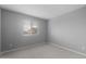 A well lit empty bedroom with carpeted floors and a view through a window with blinds at 17812 W Getty Dr, Goodyear, AZ 85338