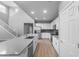 Spacious kitchen with stainless steel appliances, an island sink, and an adjacent staircase at 17812 W Getty Dr, Goodyear, AZ 85338