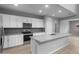 Modern kitchen featuring white cabinetry, stainless steel appliances, and a large center island at 17812 W Getty Dr, Goodyear, AZ 85338