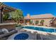 Backyard with swimming pool, outdoor fire pit, covered patio, outdoor kitchen, and well-maintained landscaping at 18036 N 49Th St, Scottsdale, AZ 85254