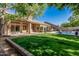 Expansive backyard with a covered patio, pool, lush lawn, and ample space for entertaining at 18036 N 49Th St, Scottsdale, AZ 85254