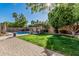 Spacious backyard with pool, patio, outdoor kitchen, lush lawn and mature landscaping at 18036 N 49Th St, Scottsdale, AZ 85254