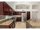 Kitchen with stainless steel appliances, stone countertops, island with breakfast bar, and dark cabinets at 18036 N 49Th St, Scottsdale, AZ 85254
