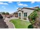 A well-maintained back yard with a paved patio, grassy area, and desert landscaping at 1961 E Stacey Rd, Gilbert, AZ 85298
